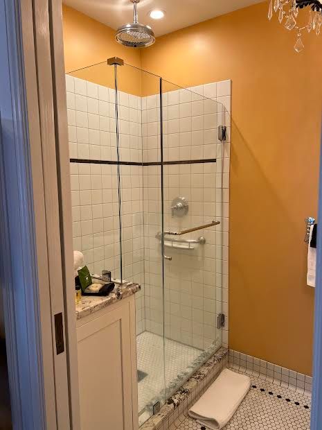A bathroom with a walk in shower and a sink.