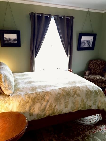 A bedroom with a bed and two pictures on the wall