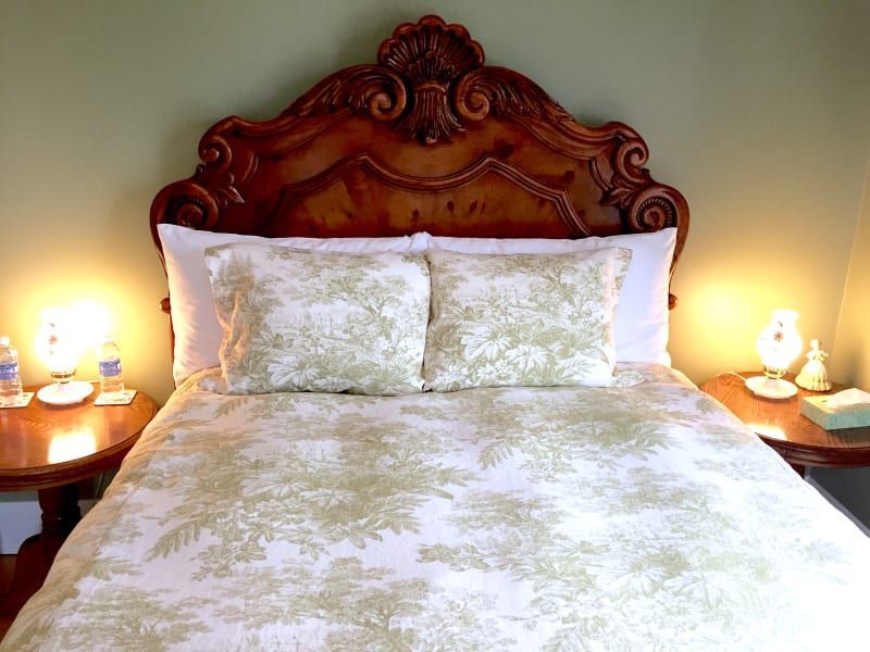 A bed with a wooden headboard and pillows in a bedroom