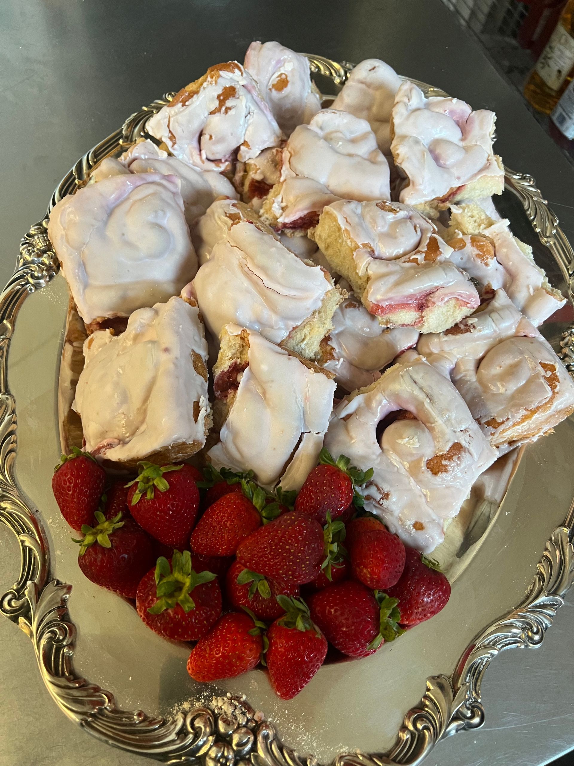 A silver plate topped with a variety of pastries and strawberries