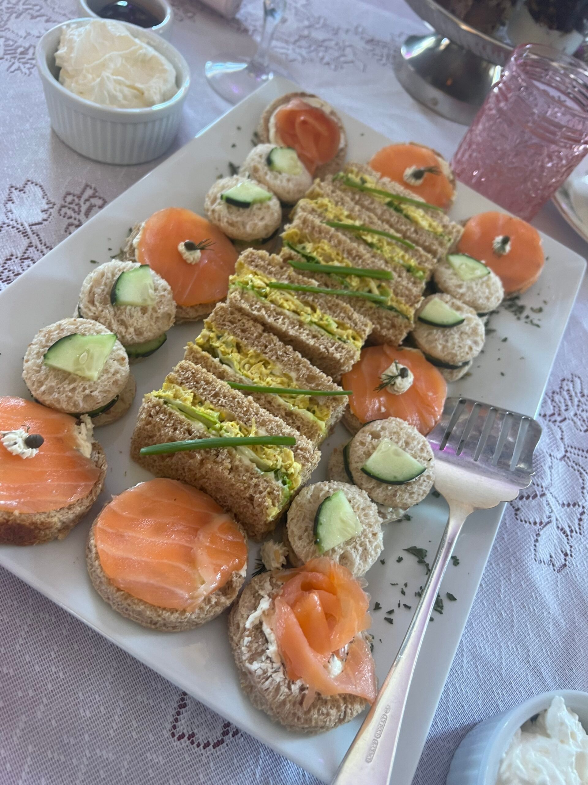 A white plate topped with sandwiches and appetizers on a table.