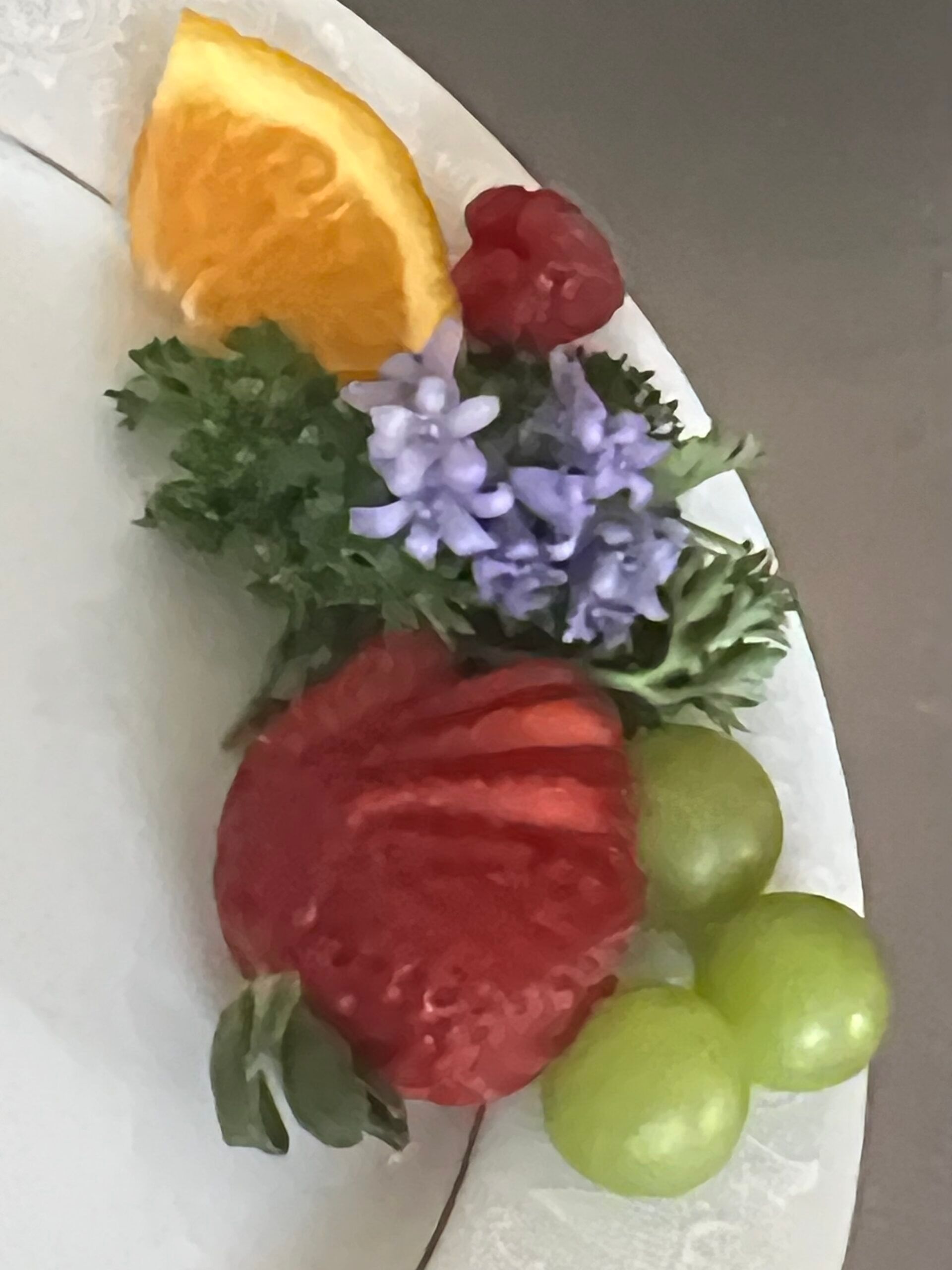 A white plate with fruit and flowers on it