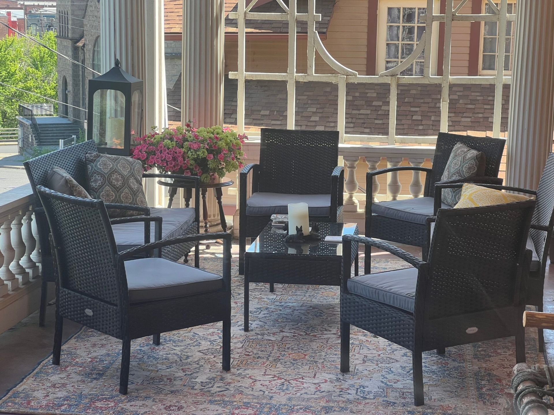 A patio with wicker furniture and a glass table
