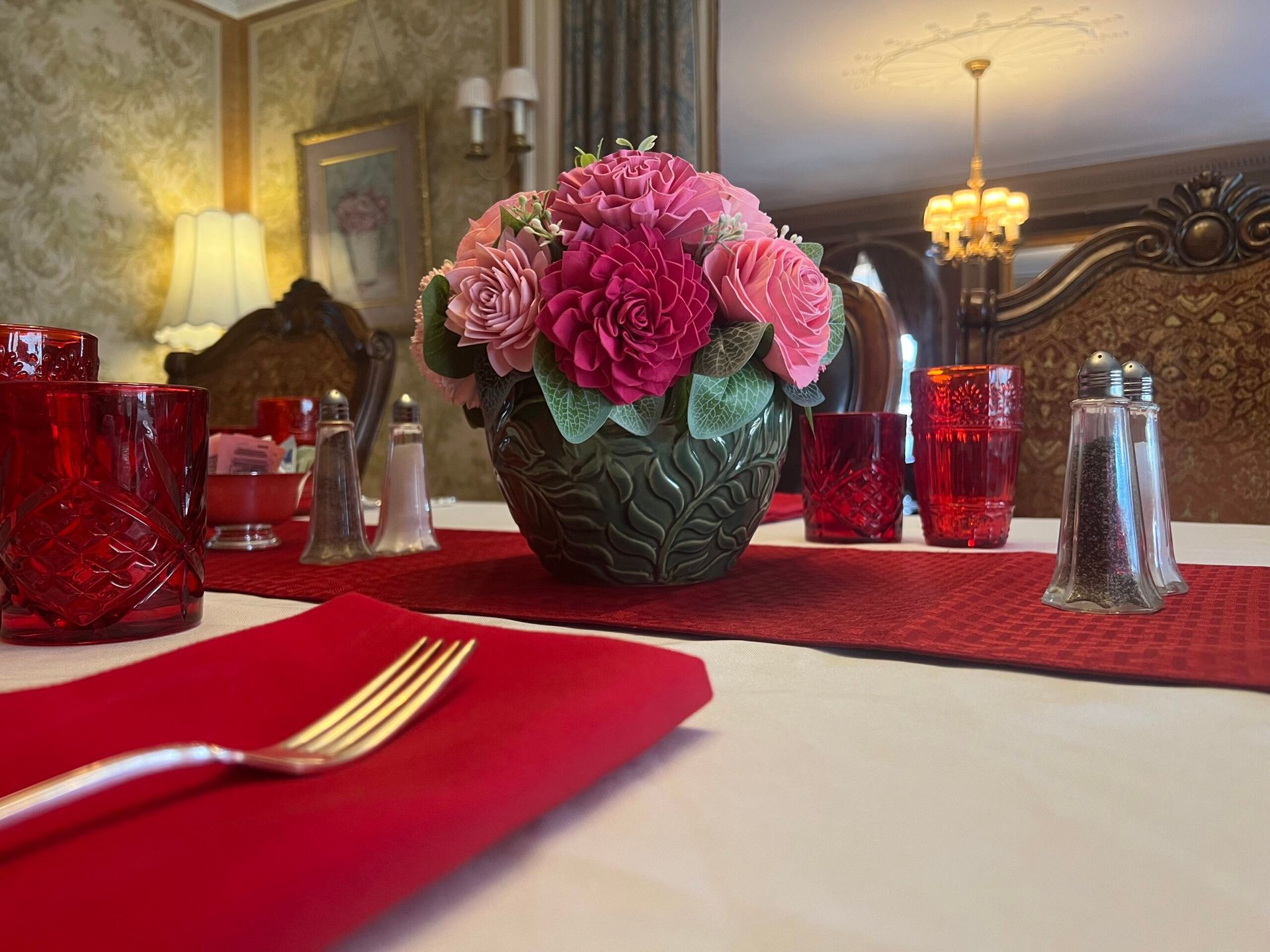 A table with a vase of pink flowers on it.