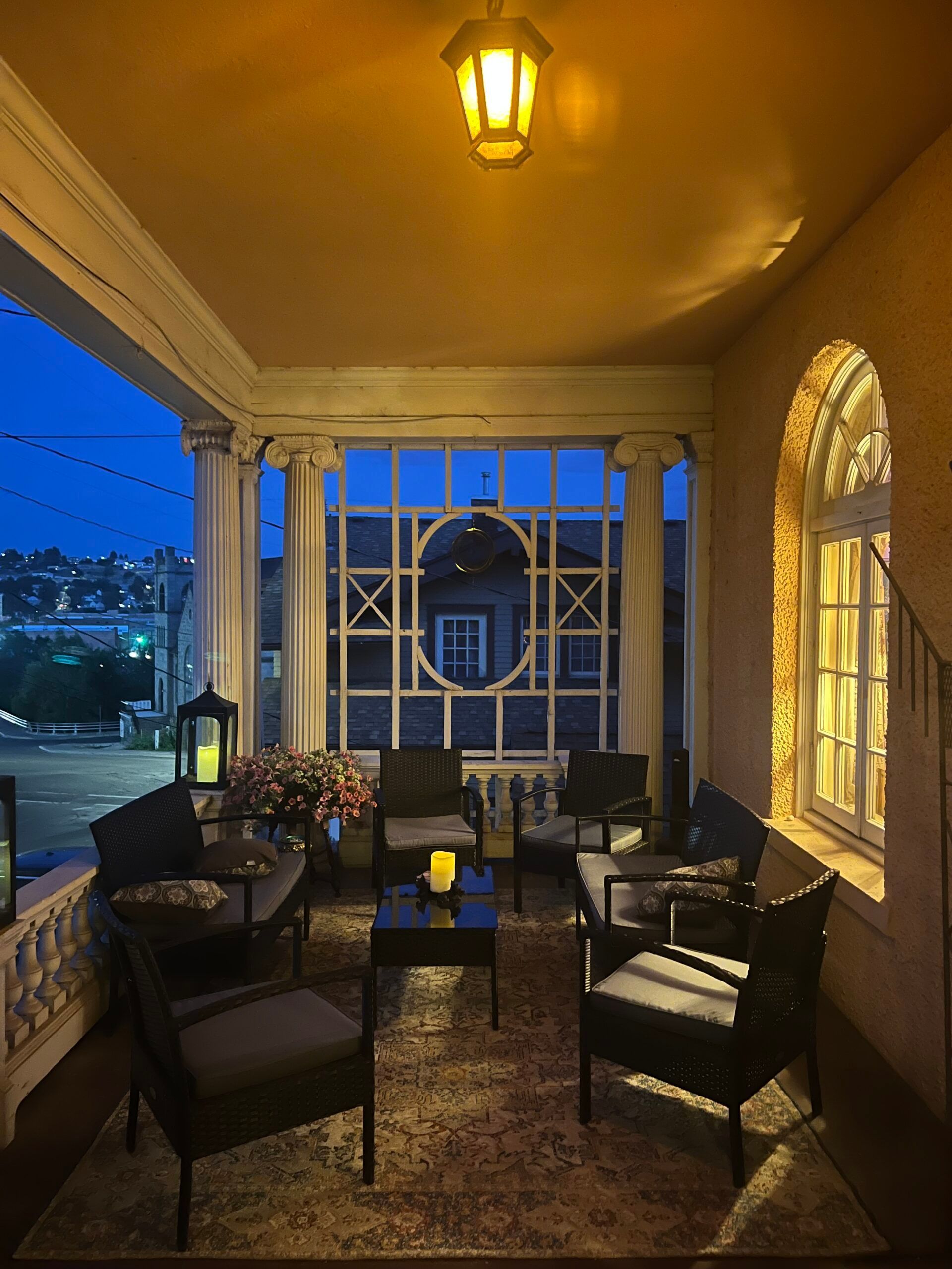 A room with a lot of furniture and a lantern on the ceiling