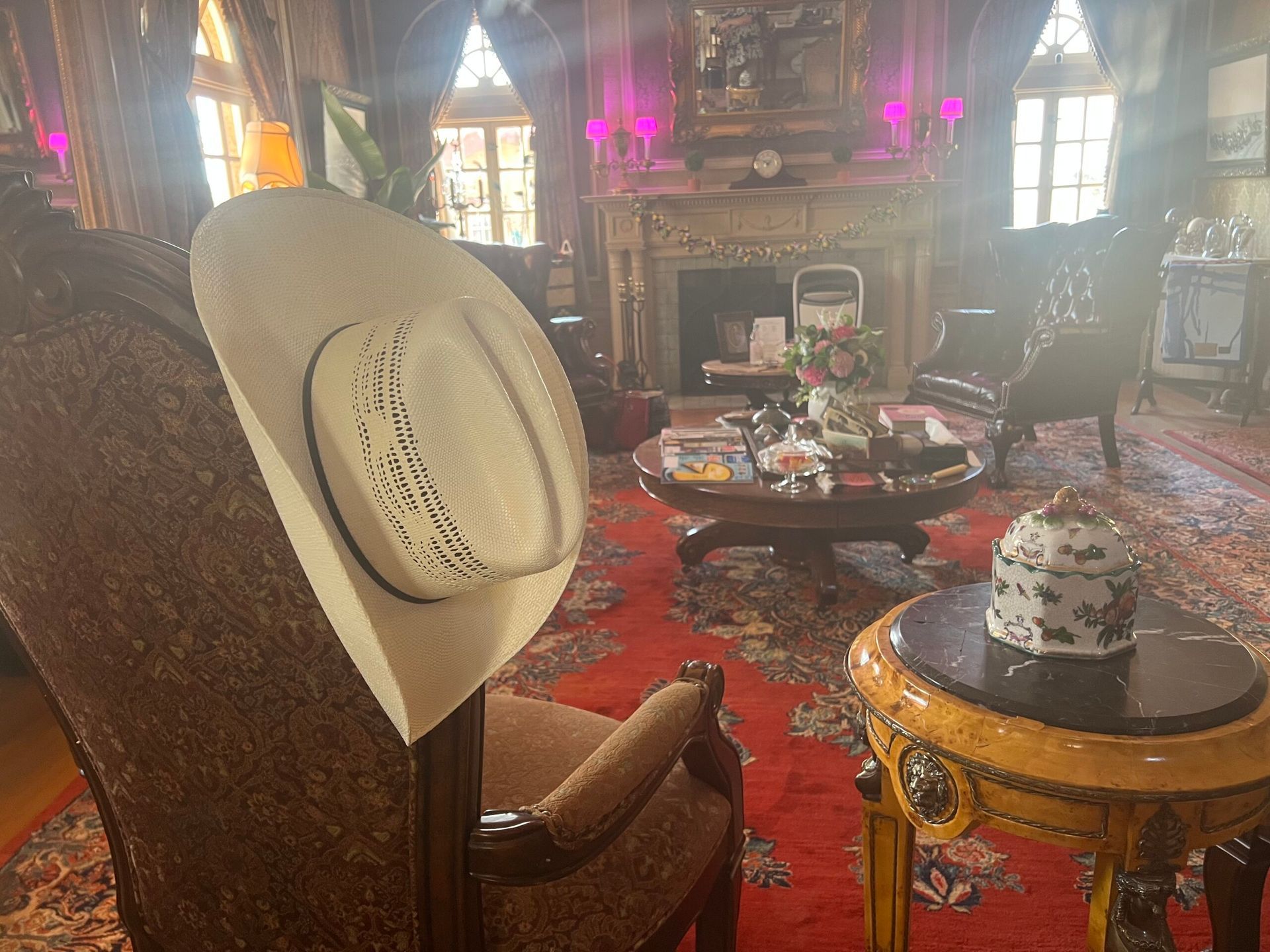 A cowboy hat is sitting on a chair in a living room.