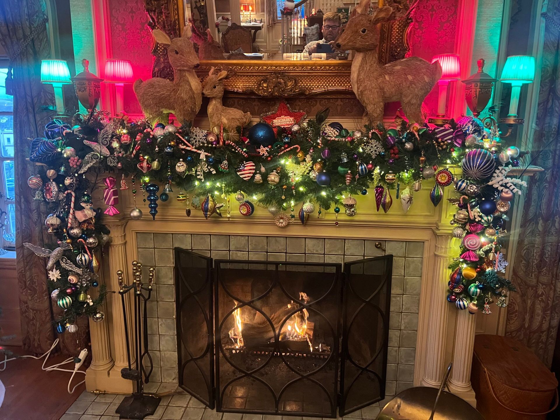 A fireplace is decorated with christmas decorations and a christmas tree.