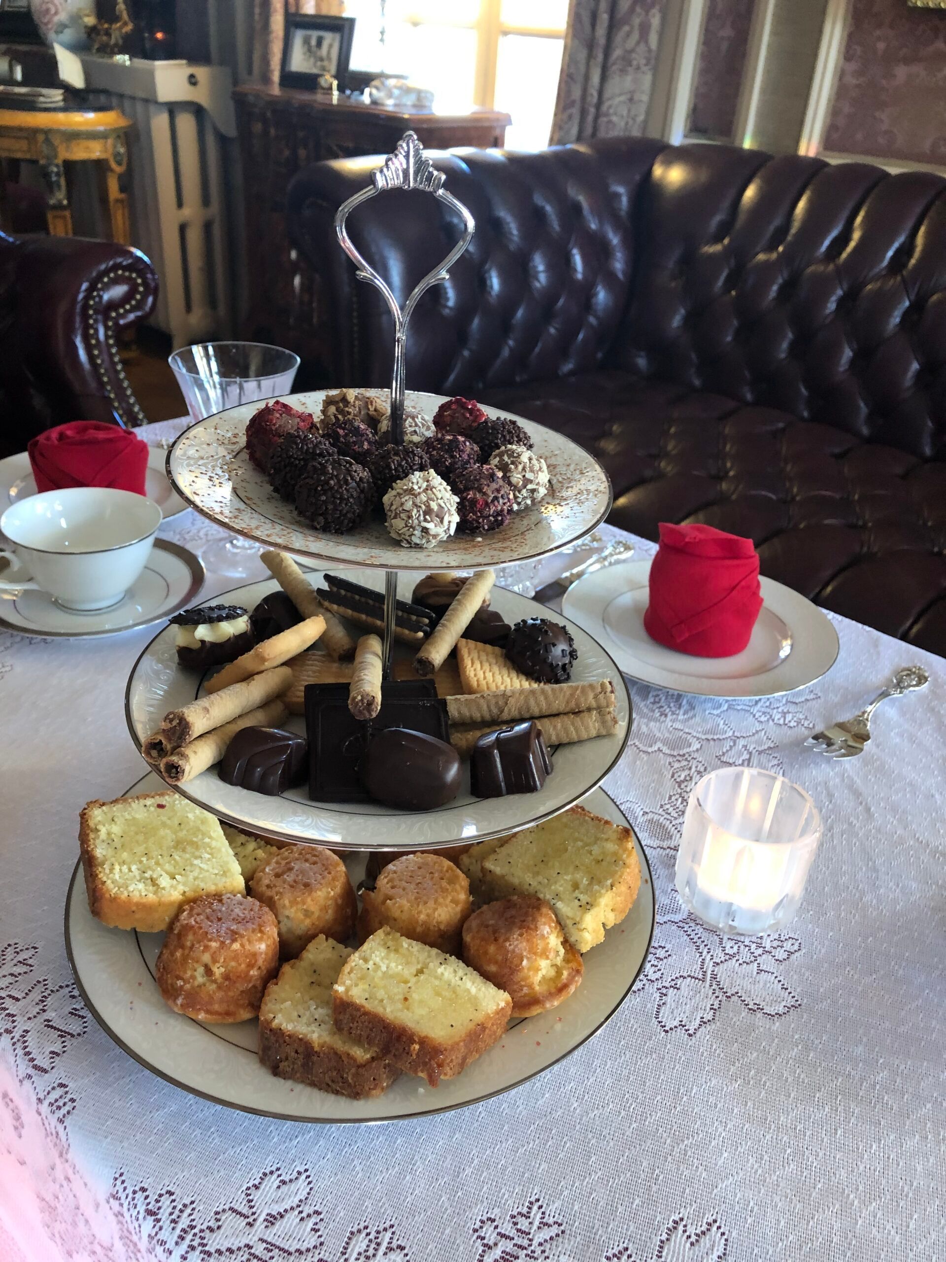 A table with three plates of food on it and a couch in the background.