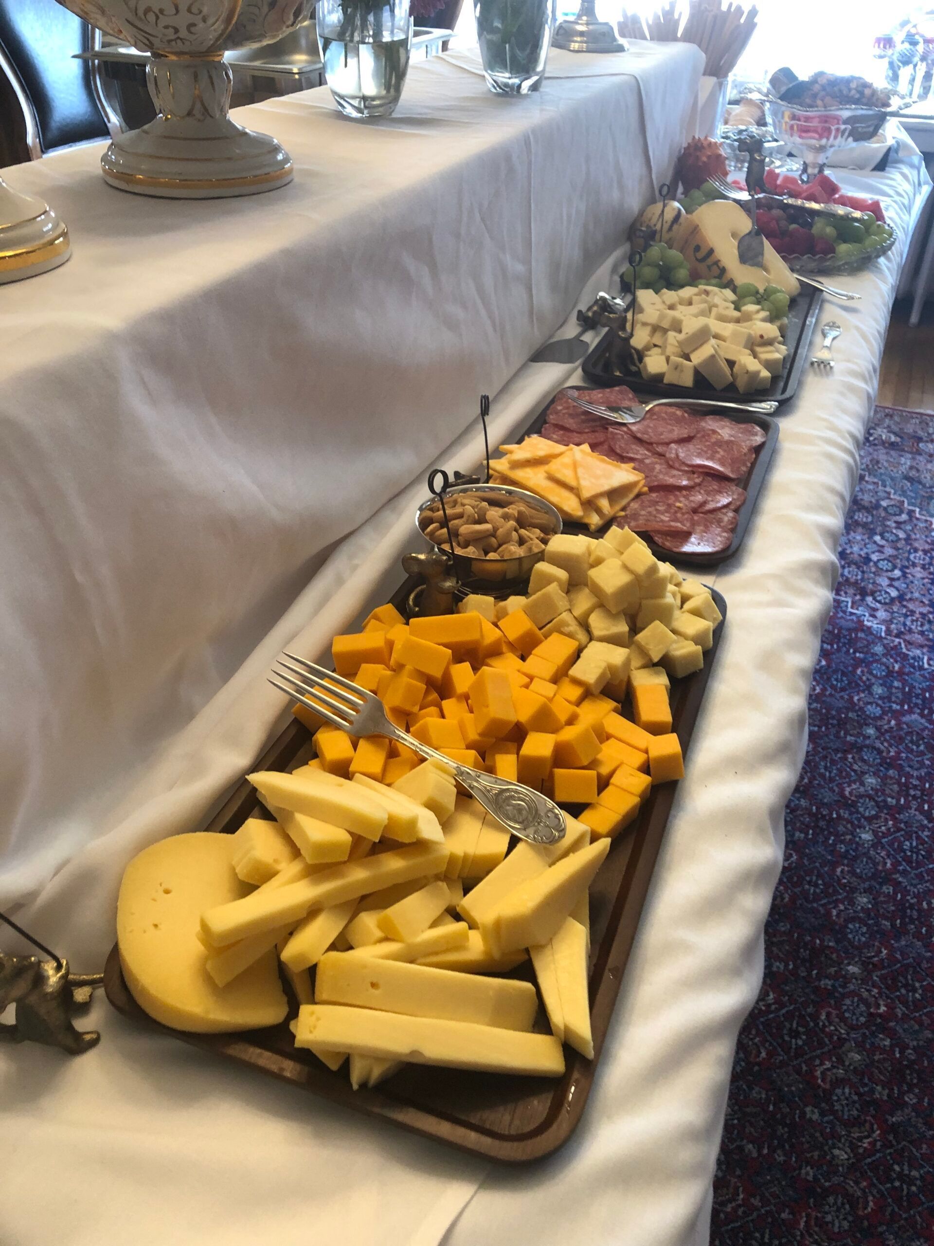 A buffet table with a variety of cheeses and meats