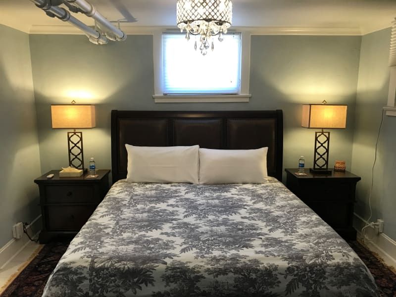 A bedroom with a bed lamps and a window