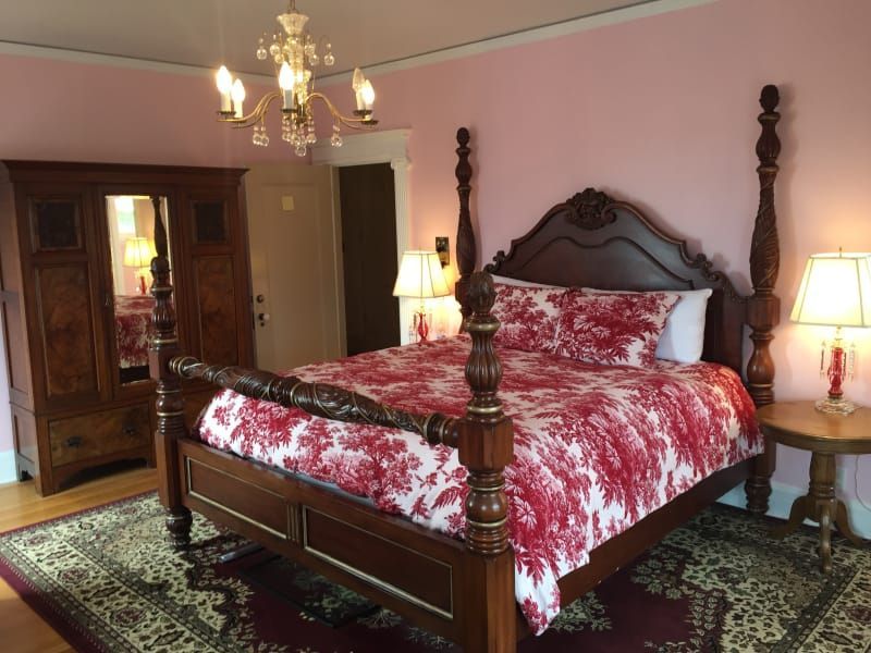 A bedroom with a king size bed and pink walls