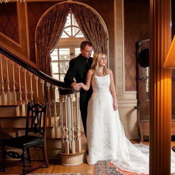 A bride and groom standing next to each other on a staircase