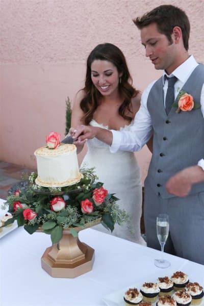 A bride and groom are cutting their wedding cake
