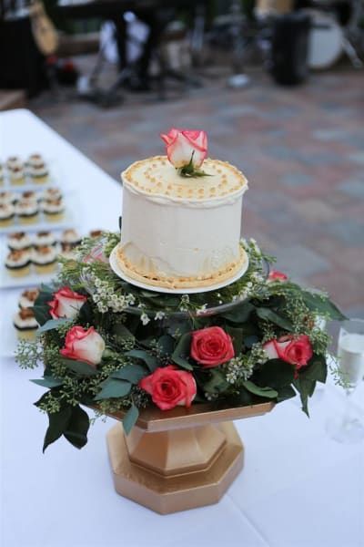 A white cake with red roses on top of it