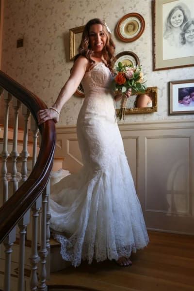 A woman in a wedding dress is standing on a set of stairs
