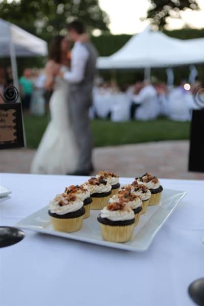 A plate of cupcakes with a bride and groom in the background
