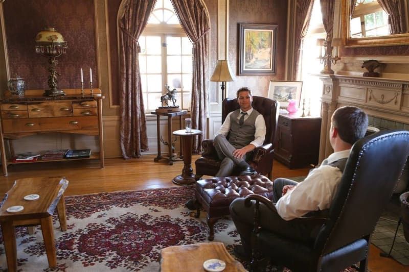 Two men are sitting in chairs in a living room