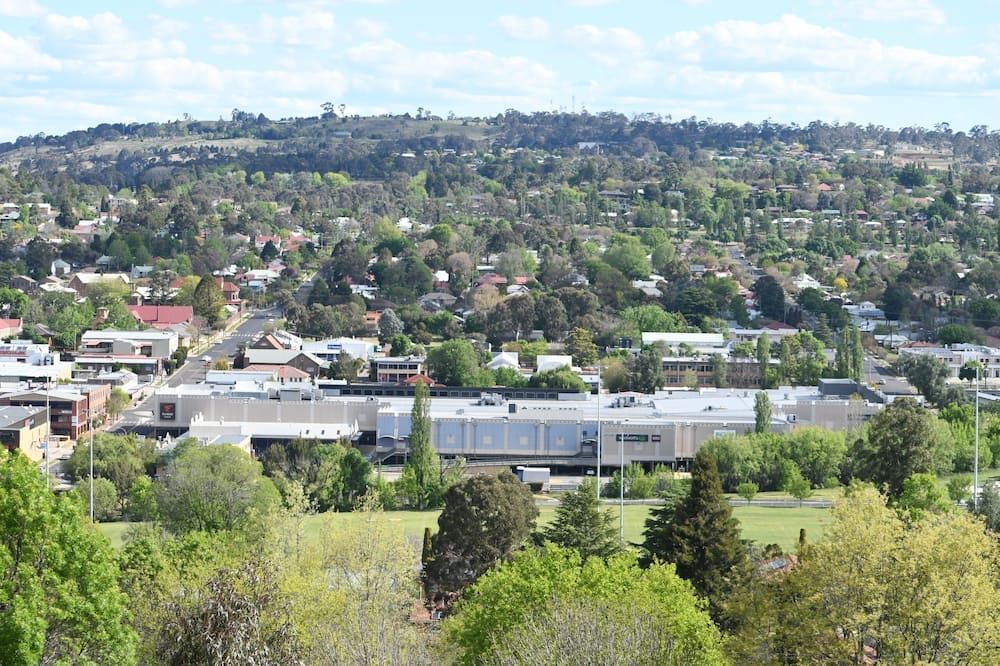 An Aerial View of a City Surrounded by Trees and Buildings — Tamworth Interiors in Armidale, NSW