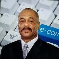 Man in suit, smiling, with e-commerce keyboard background.