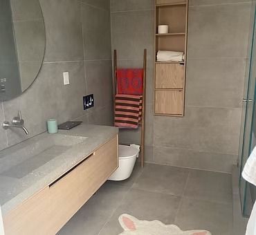 A bathroom with a sink , toilet , mirror and towel rack.
