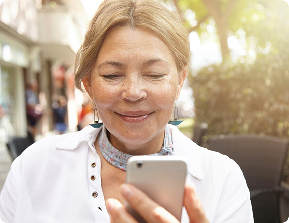 Medical team looking at a laptop, discussing. Light-skinned and Black medical professionals in lab coats and scrubs in a bright room.