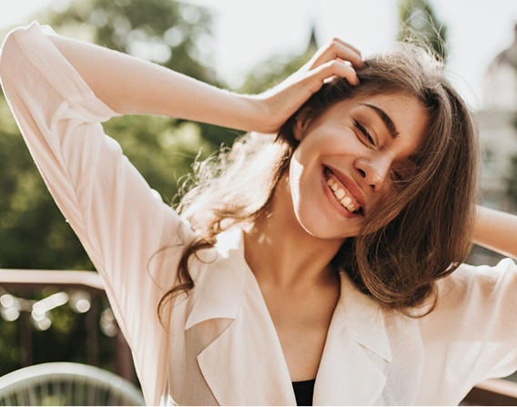 Medical team looking at a laptop, discussing. Light-skinned and Black medical professionals in lab coats and scrubs in a bright room.