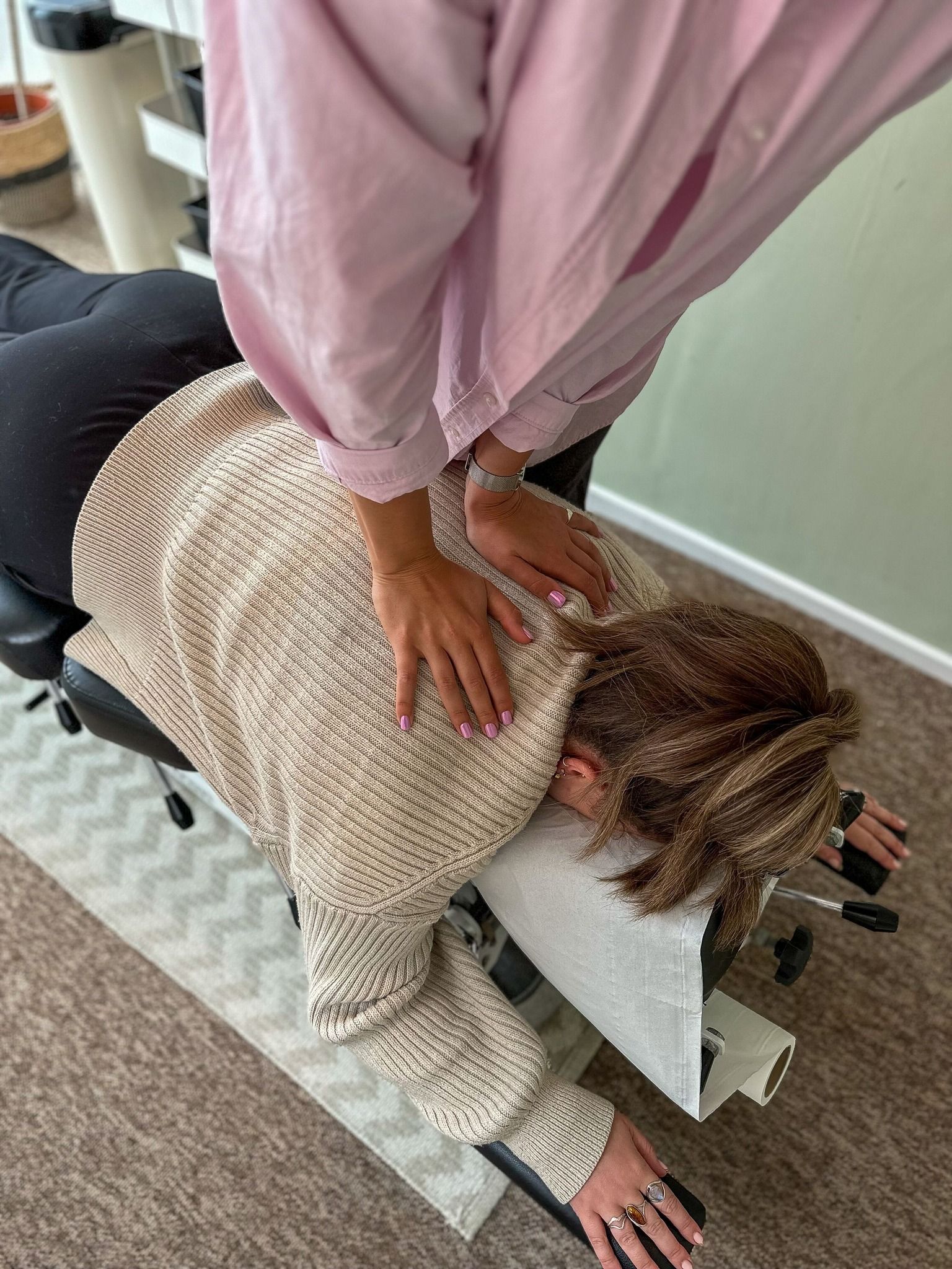 A woman is laying on a table getting a chiropractic treatment.