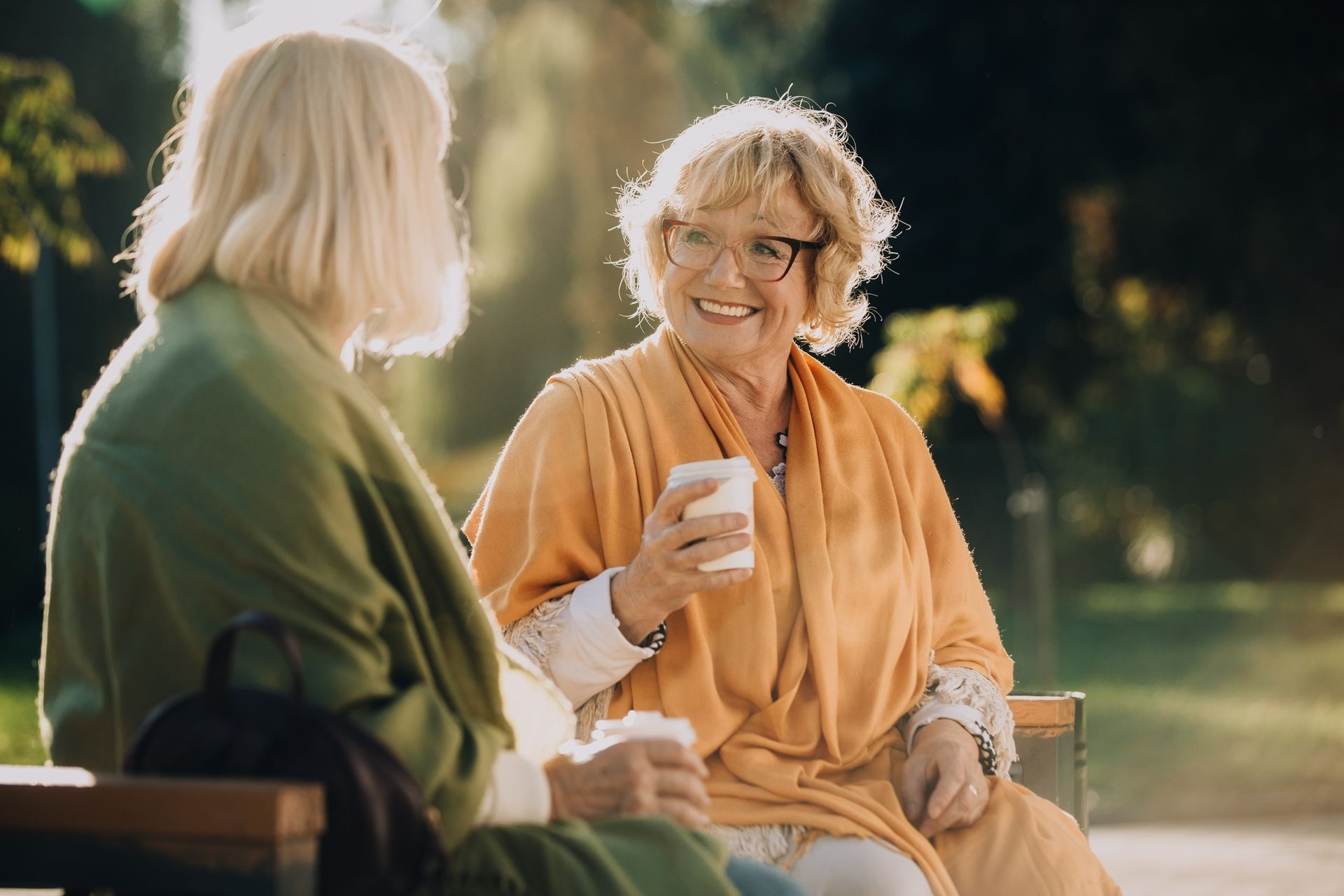Twee dames op een bankje met een kop thee, een Gea ondersteuner met haar cliënte.