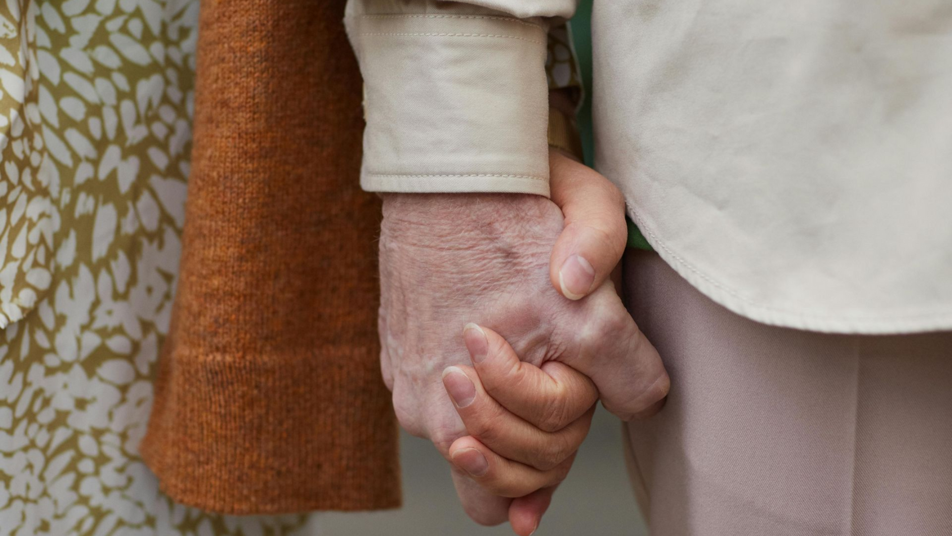 Een ouder echtpaar dat liefdevol elkaars hand vast heeft