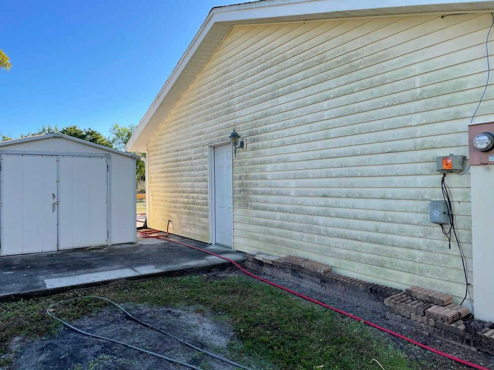 A house with a garage and a shed in the backyard.