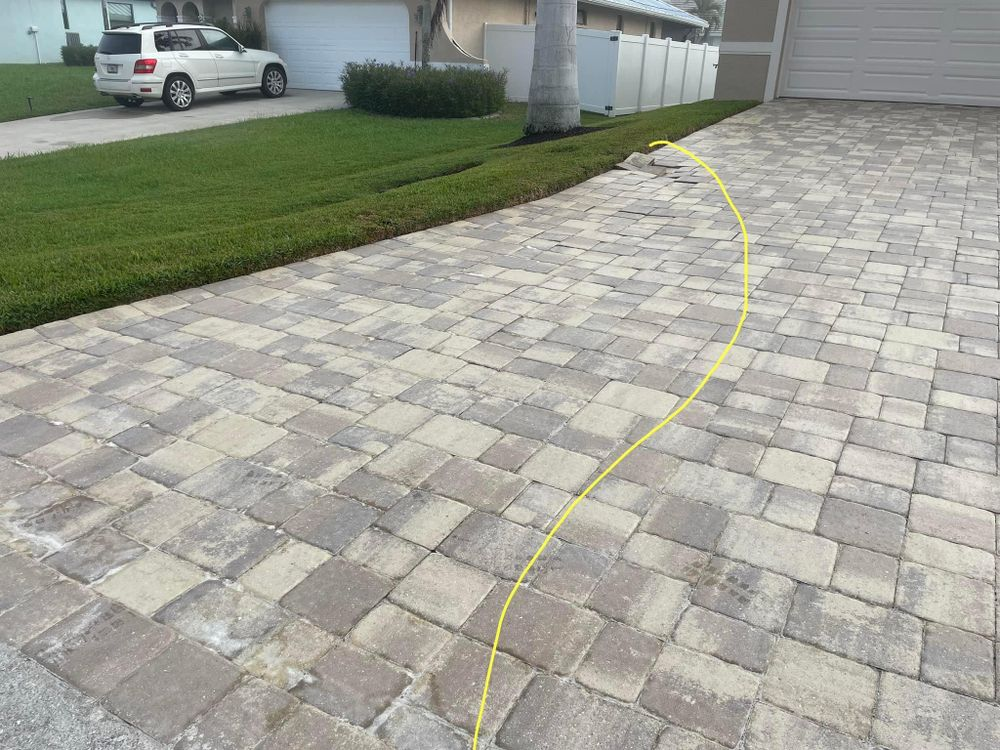 A white suv is parked in a driveway next to a garage.
