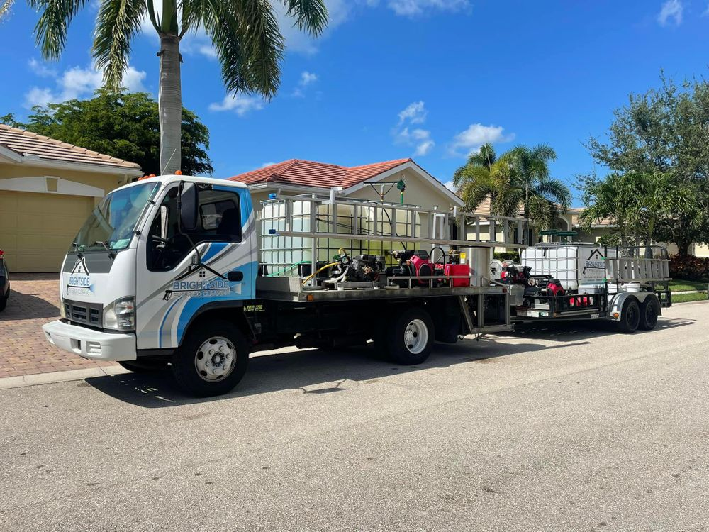 A truck with a trailer attached to it is parked in front of a house.