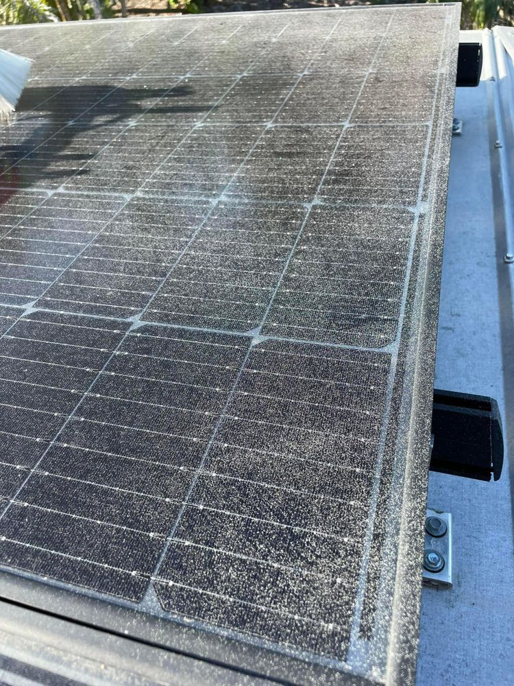 A close up of a dirty solar panel on a roof.