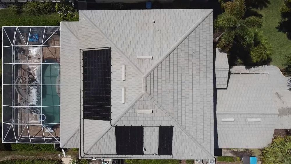 An aerial view of a house with solar panels on the roof.