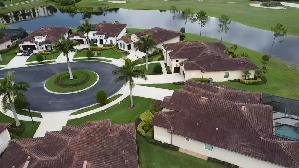 An aerial view of a residential area with houses and a golf course.