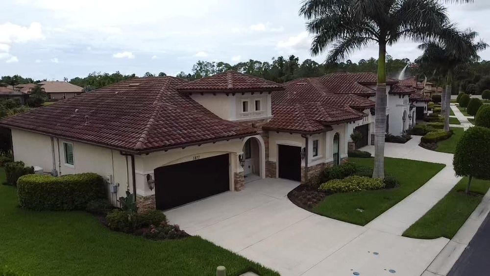 An aerial view of a large house with a palm tree in front of it.