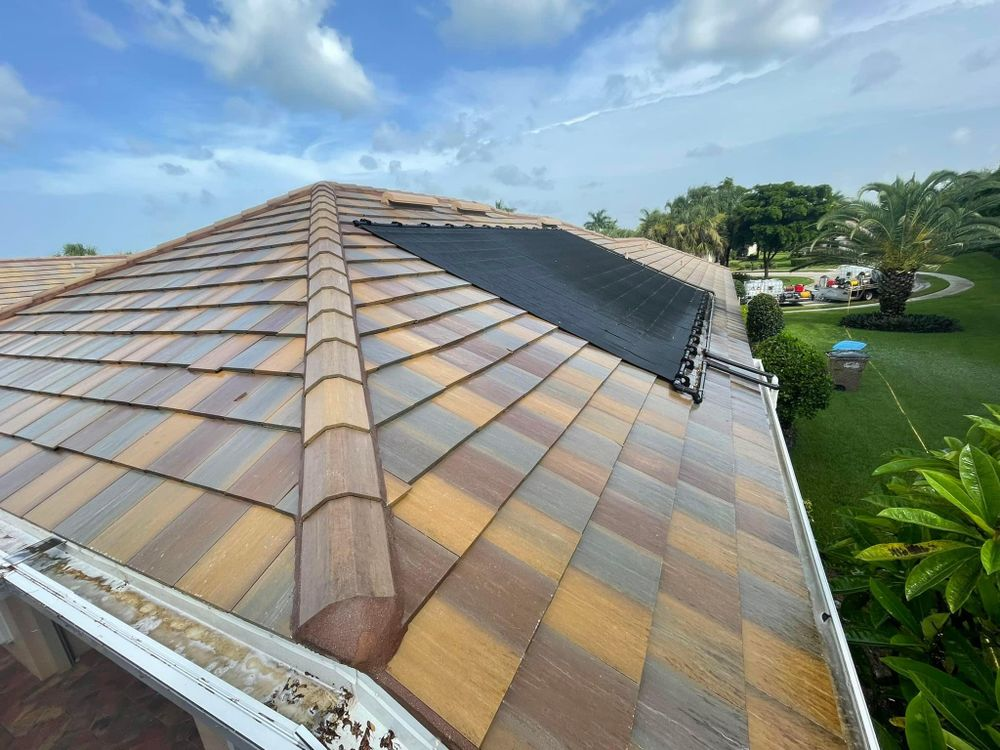 The roof of a house with a solar panel on it.