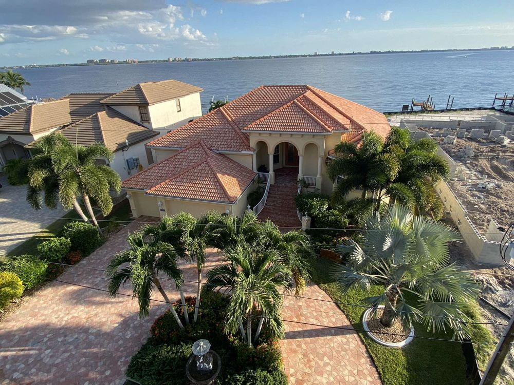 An aerial view of a large house next to a body of water.