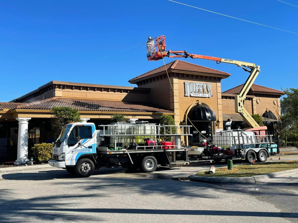 A truck with a crane on top of it is parked in front of a building.