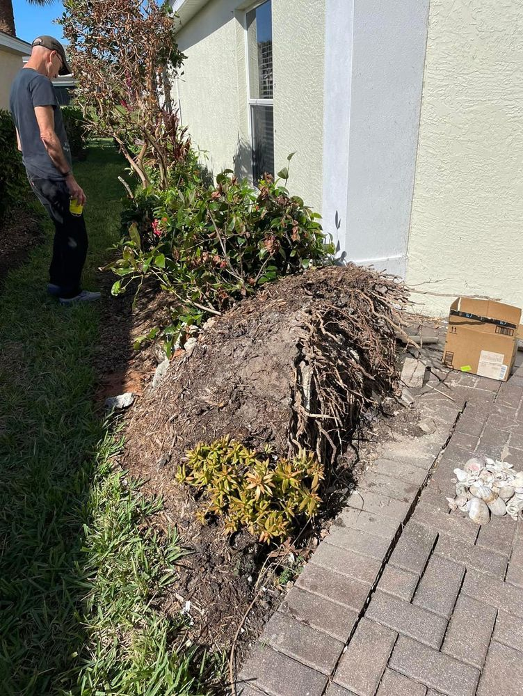 A man is standing next to a pile of dirt in front of a house.