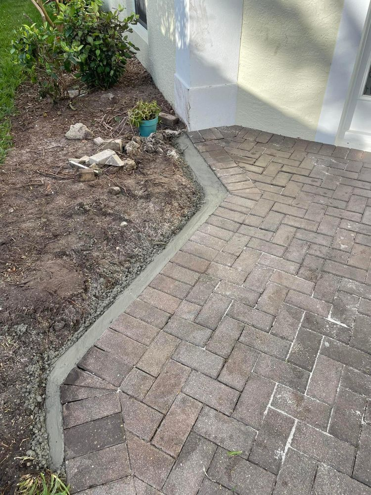 A brick walkway is being built in front of a house.