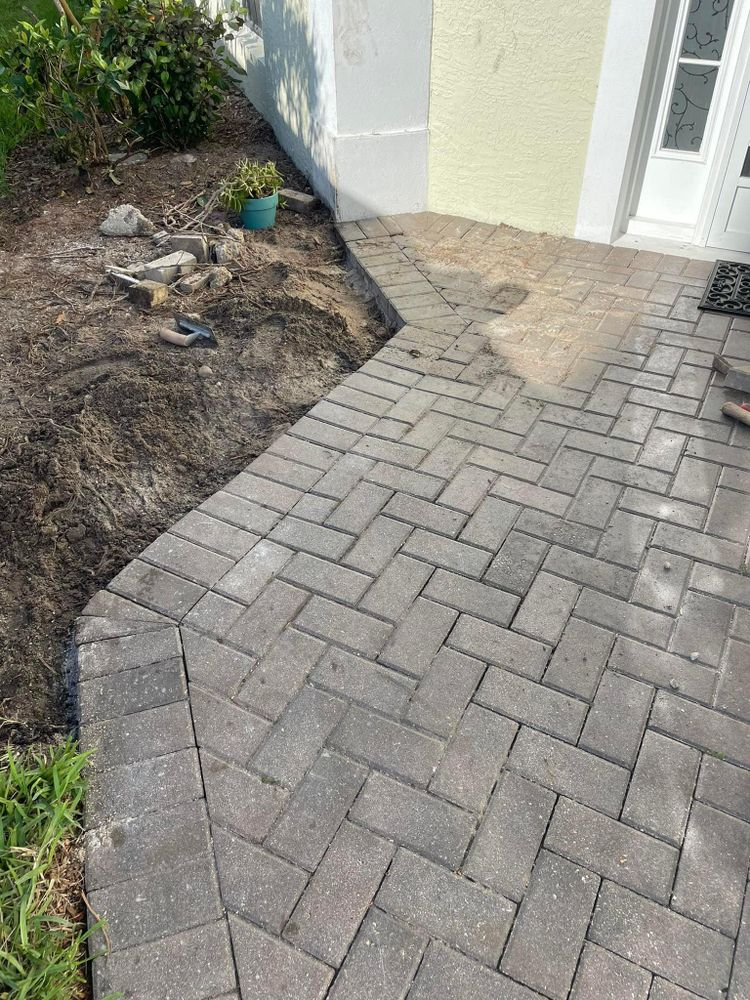 A brick walkway is being built in front of a house.