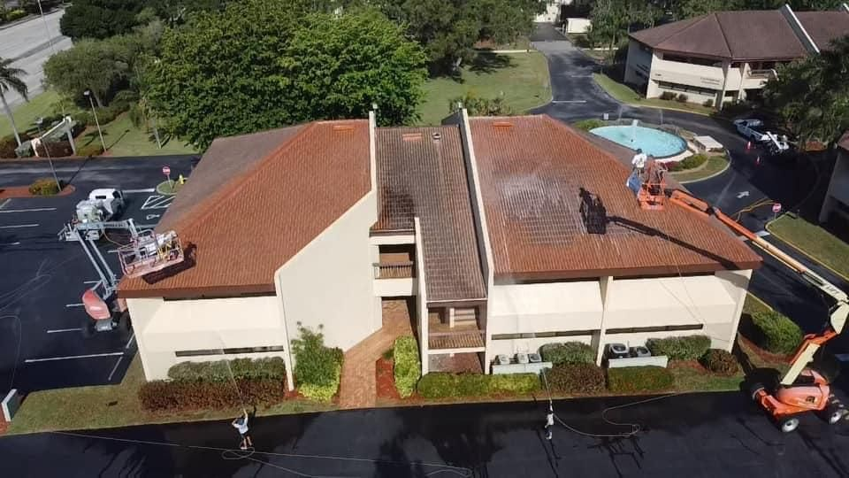 A group of people are cleaning the roof of a building.