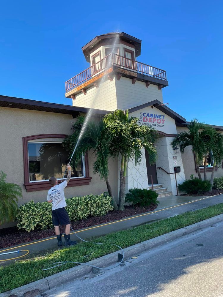A man is spraying water on the roof of a building.