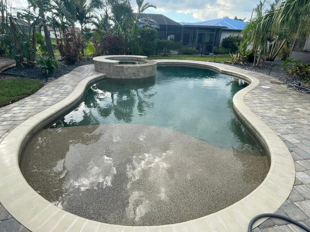 A large swimming pool with a hot tub in the middle of it
