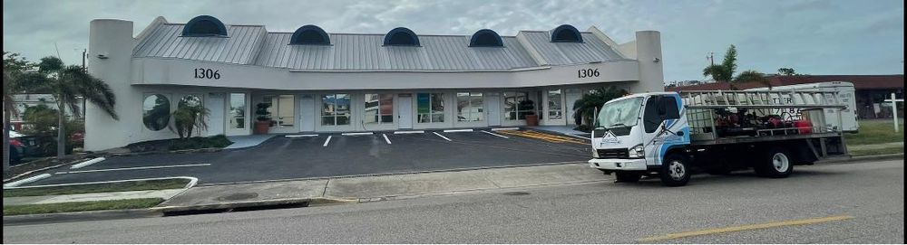 A tow truck is parked in front of a white building