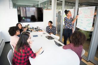 A group of people are sitting around a table in a conference room.