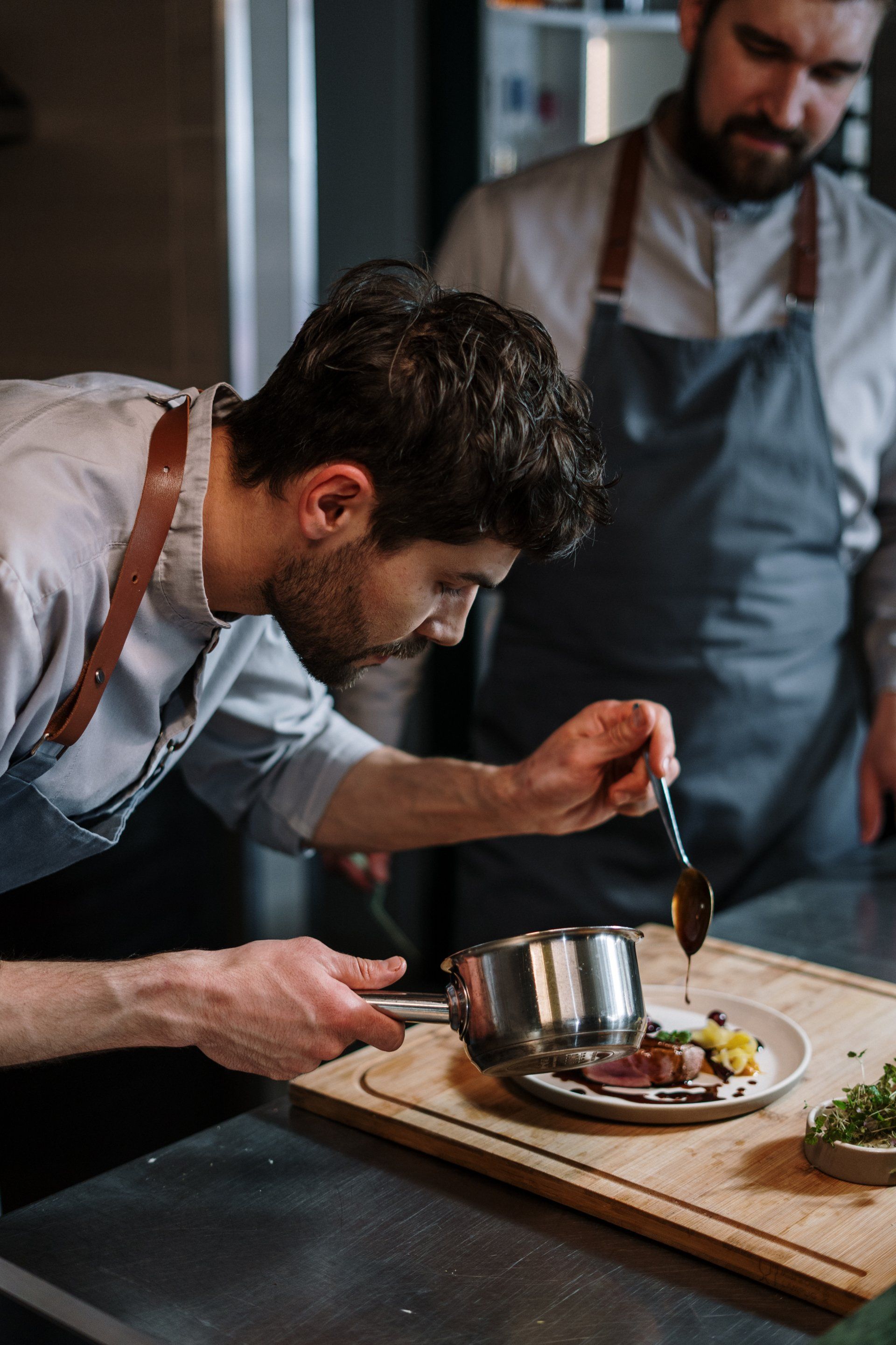 Two men are preparing food in a kitchen.