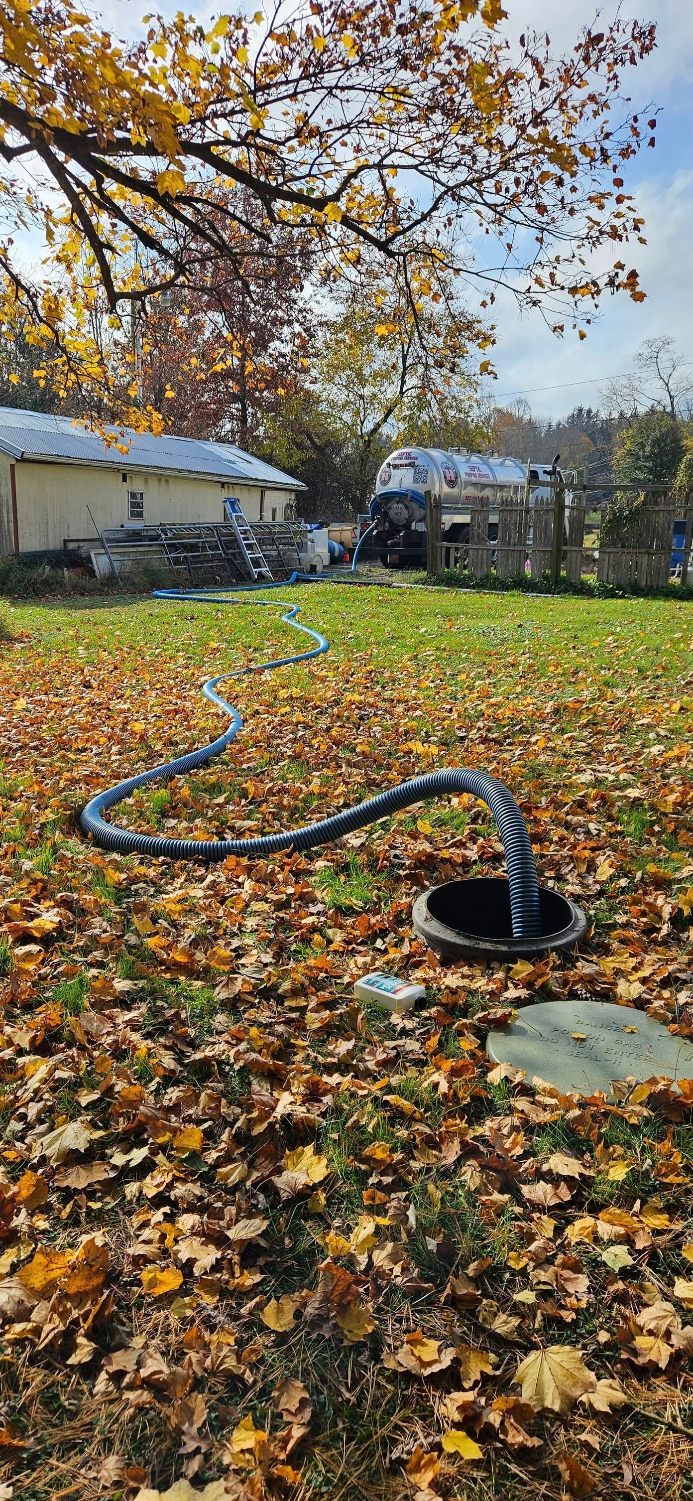 Person using a pump to remove water from a large, open metal container. Person using a pump to remove water from a large, open metal container.