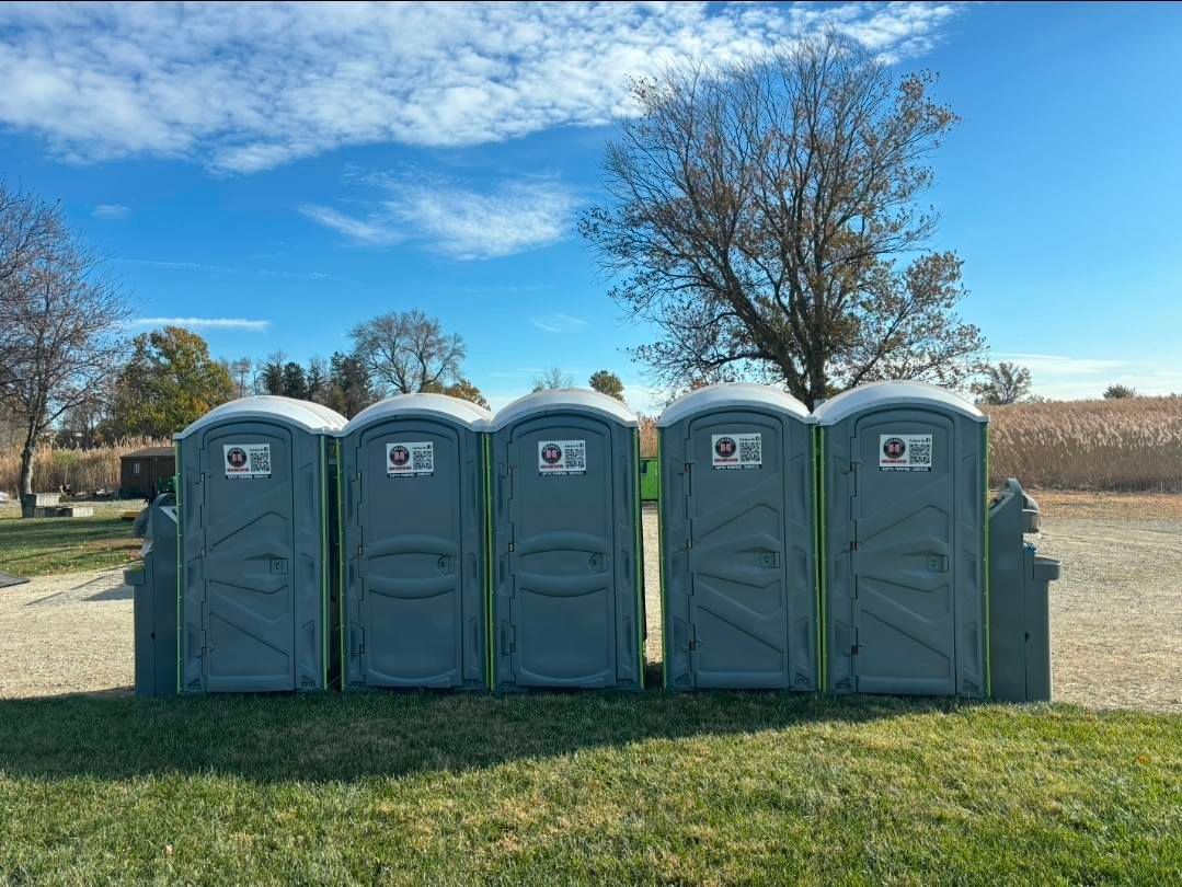 Person cleaning a septic tank access point with a hose in a grassy area. Person cleaning a septic tank access point with a hose in a grassy area.